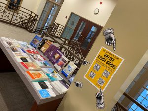Various books displayed on a table with a sign about online study guides