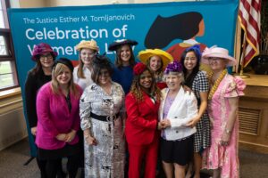 Justice Tomljanovich (in purple hat) with alumnae at the Justice Esther M. Tomljanovich Celebration of Women in Law Tea, 2024