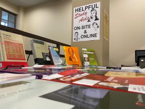 An image of books display on a table and a sign that says "Helpful study aids on-site and online" 